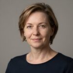 Портрет уверенного российского бизнесмена с дружелюбным взглядом на нейтральном размытом студийном фоне